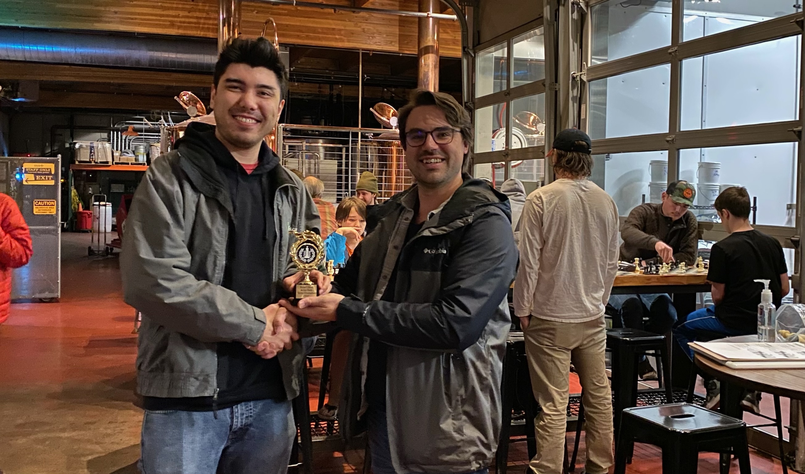 Joe L (left) receives the 2022 Chess Champion trophy